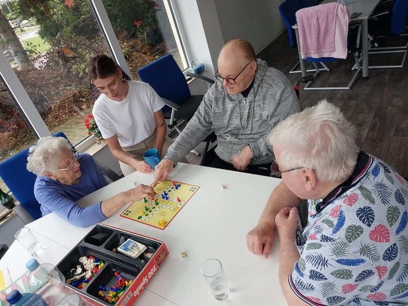 Ebert & Ebert Tagespflegen GmbH - Tagespflege am Markt - Ebert & Ebert Tagespflegen GmbH - Senioren sitzen zusammen und spielen Ludo